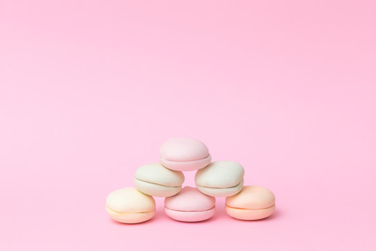 Delicate colored marshmallows on a pink background minimal style. Copy space