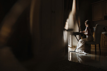 Bride playing the piano photographed from the side