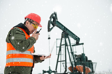 Oil Drill, oil and gas field ,pump jack,  snow storm and worker.