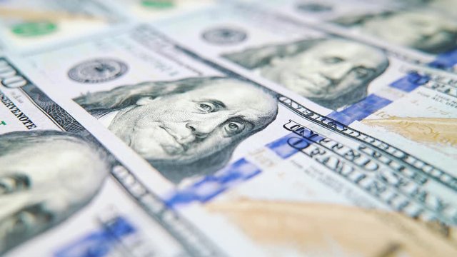 Macro dolly shot of US dollar bills lying in row