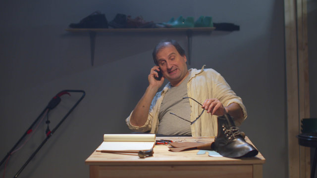 Craftsman at the workbench talking on the phone