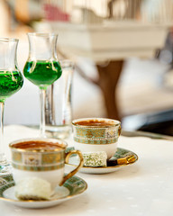 two cups of turkish coffee served with sweets
