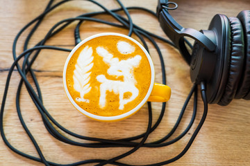 coffee and headphones on a wooden background