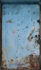 Old blue metal door. Vintage texture with peeling paint