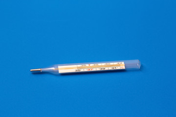 Mercury thermometer on a blue background