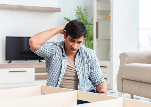 Man assembling furniture at home
