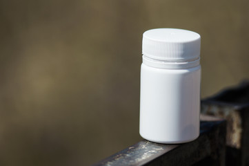 White  pills lie on a metal railing