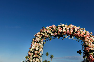 Decorazione floreale a forma di cuore di altare per una cerimonia al mare, sfondo cielo blu