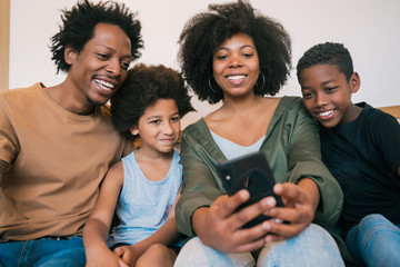 Family taking selfie together with phone at home.