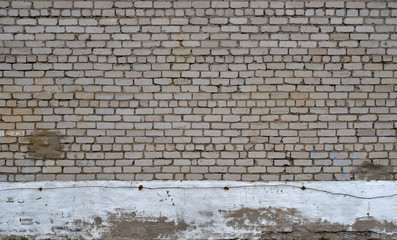 Grey brick wall with traces of destruction and dirty texture