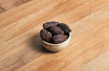 Dates fruit and ethnic coffee cup on wooden table. The Muslim feast of the holy month of Ramadan.