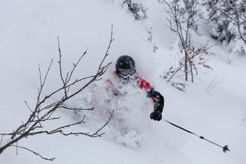 Freerider is buried in fresh snow, turning and jumping between the trees. freeride skiing in deep...