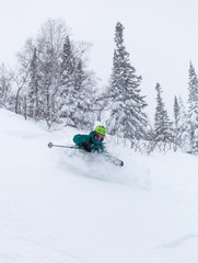 Freerider is buried in fresh snow, turning and jumping between the trees. freeride skiing in deep...