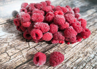 Frozen raspberries on wooden background