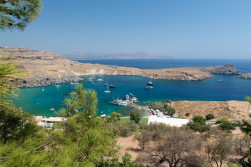 Fototapeta na wymiar RHODES, GREECE - AUGUST 2020: Blue lagoon with transparent water at Lindos town.