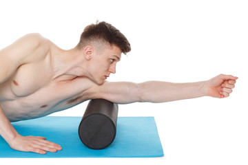 Obraz premium Handsome man shows exercises using a foam roller
