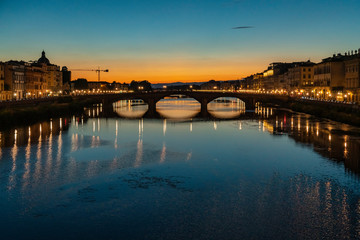 Wide angle night view of Ponte alla Carraia in Florence, Italy