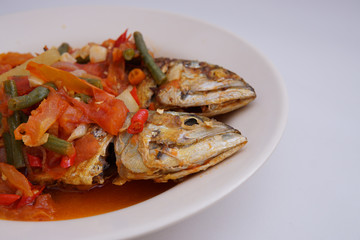 fried fish with chili sauce and tomatoes on top isolated white background