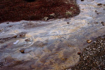 Hot water runoff from the Stokkur Geyser in Iceland and the surrounding landscape
