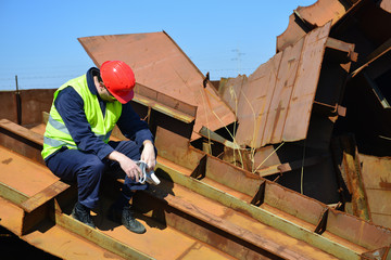 Tired worker on junkyard. Copy space available.