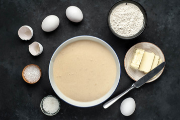 The recipe for making homemade pancakes from
flour, eggs, butter, milk, salt, sugar on a stone background