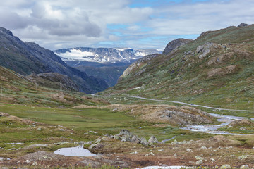 Dirt road passing in a valley between mountains in Norway, selective focus