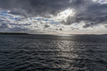 Norwegian fjord and mountains surrounded by clouds, ideal fjord reflection in clear water. selective focus.
