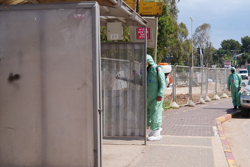 A person disinfects a bus stop from the Corona virus.
