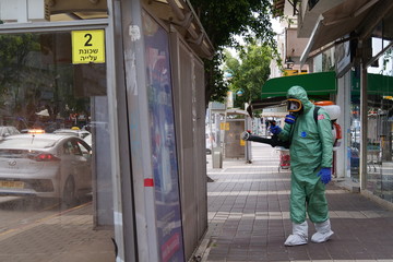 A person disinfects a bus stop from the Corona virus.
