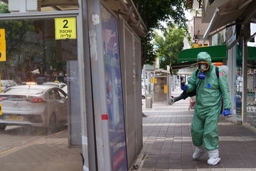 A person disinfects a bus stop from the Corona virus.
