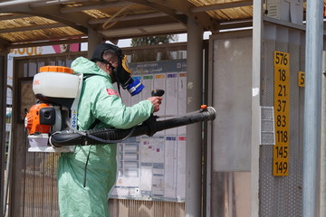 A person disinfects a bus stop from the Corona virus.
