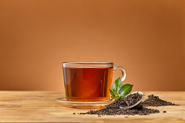 Glass cup of tea brown background. Close up.
