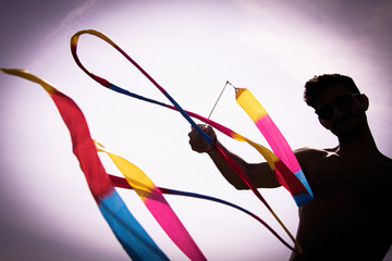 Un hombre haciendo piruetas con un juguete colorido y sombras.  © Rocío González 