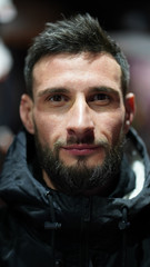 Portrait of stylish young man with black beard on blurry background