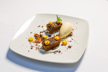 Dessert served on white plate, raw cake with vanilla ice cream