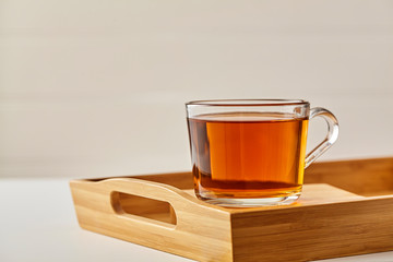 Glass cup of tea brown background. Close up.