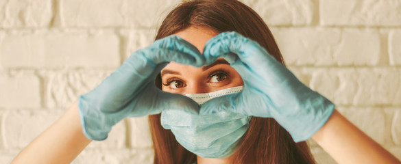 Banner young woman in protective face mask and medical gloves gesturing love shape sign. Happy girl...