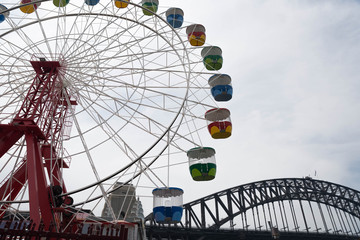 Sydney, NSW - November 28 2019: The Carousel in Luna Park with the Sydney Harbor Bridge in the...