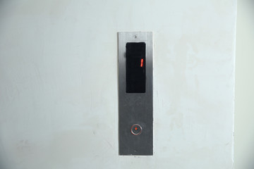 The modern lift button panel on stone tite wall close up background. Here are elevator button of...