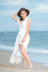 Fototapeta na wymiar Beautiful women in white dress happily strolling at the beach, beautiful women dressed in white bride