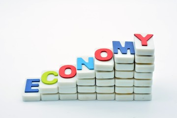 La palabra economy escrita en una escalera hecha con fichas de dominó
