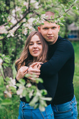 couple in blue jeans and black shirts in a green park