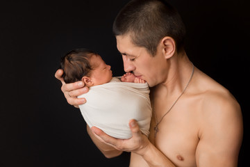 the child's head in the hands of parents. the head of the newborn in the hands of his father. the little head of a newborn