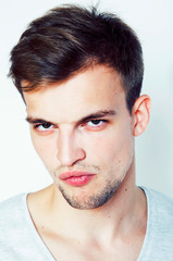 Obraz premium young handsome teenage hipster guy posing emotional, happy smiling against white background isolated, lifestyle people concept close up