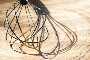 wire whisk isolated on wooden background