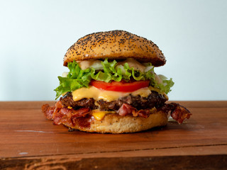 A big selfmade bacon cheeseburger, made with fresh baked buns, bacon, tomato,cheese,onions,salad and a beef patty.