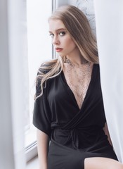 Portrait of beautiful young blonde girl with makeup  in black fashion clothes 