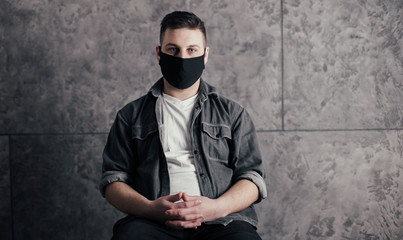 Young man with black mask in dark room pray for world and coronavirus quarantine