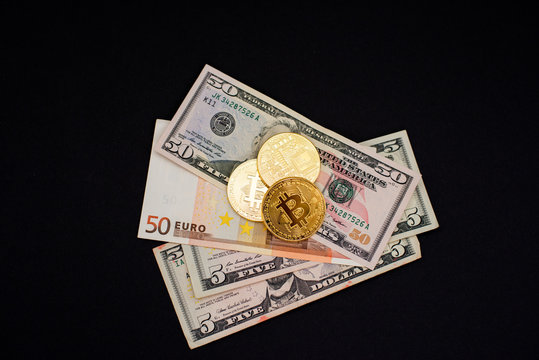 Bitcoin coins on dollar and euro bills. Virtual cryptocurrency purchase concept. Black background. Bitcoin mining, online business, shopping. Copy space