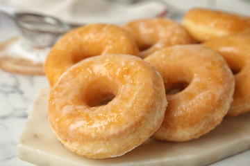 Sweet delicious glazed donuts on board, closeup